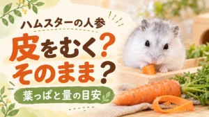白いハムスターが角切りの人参をかじり、手前に葉つきの人参とむいた皮が置かれたアイキャッチ画像